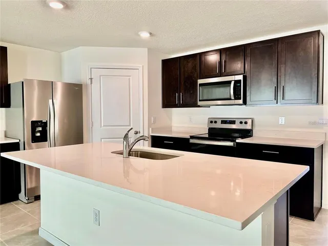a kitchen with stainless steel appliances wooden cabinets and refrigerator