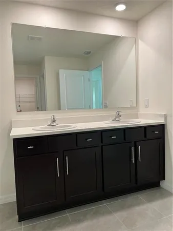 a bathroom with a double vanity sink and a mirror
