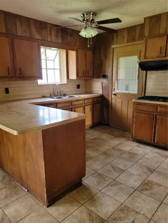 a kitchen with cabinets a window and stainless steel appliances