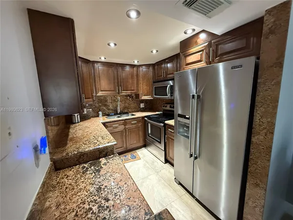 a kitchen with a refrigerator sink and a stove
