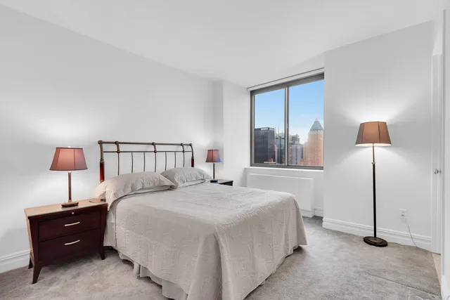 a bedroom with a large bed and a window