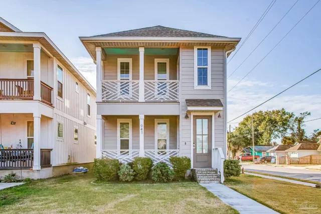 a view of a brick house with many windows next to a yard