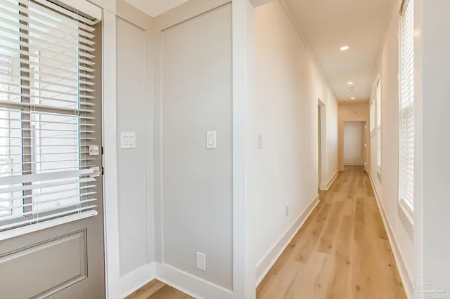 an empty room with wooden floor cabinet and windows
