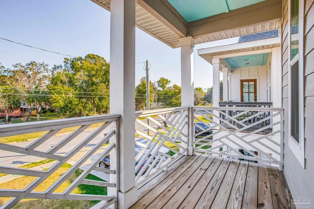 an empty room with wooden floor cabinet and windows