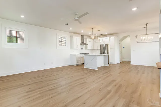 a kitchen with kitchen island white cabinets and stainless steel appliances