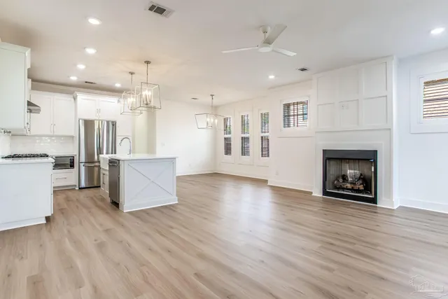 a kitchen with a refrigerator a sink and wooden floor
