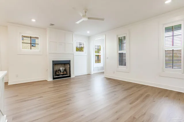 a kitchen with stainless steel appliances a stove a refrigerator a sink a oven and white cabinets with wooden floor