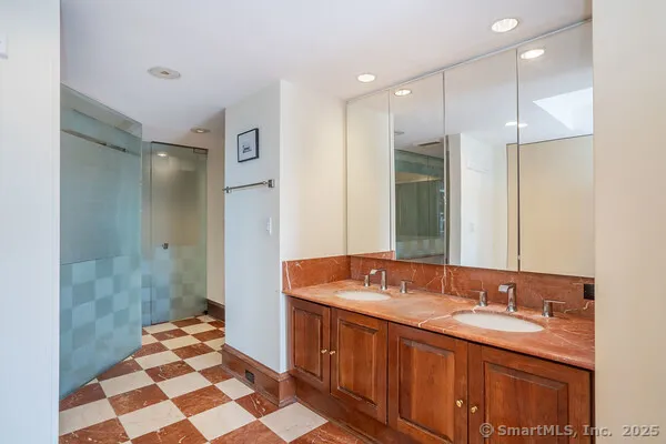 a spacious bathroom with a double vanity sink mirror and shower