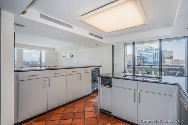 a kitchen with white cabinets and sink