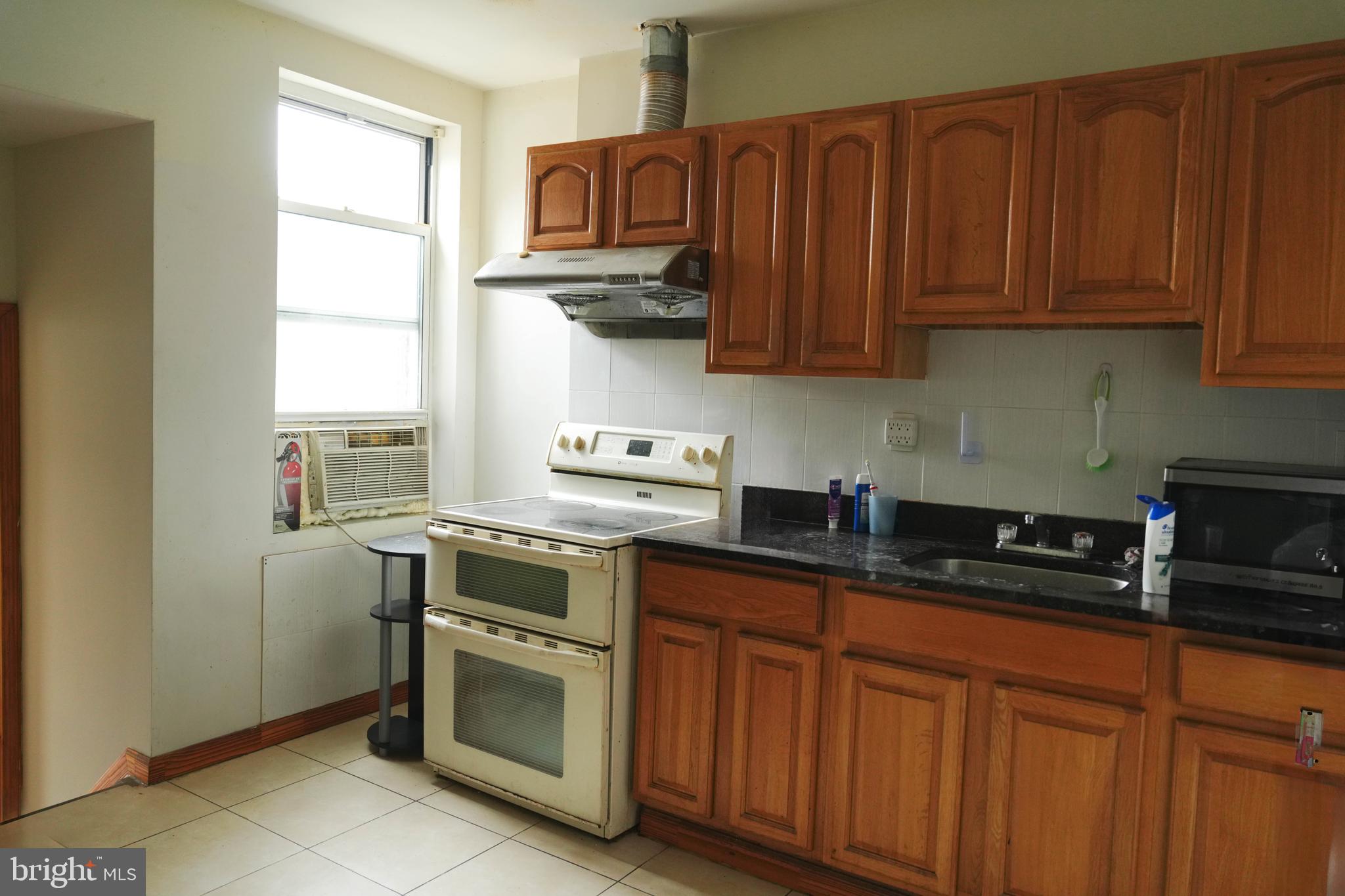 222 South 43rd Street, Unit 3 Philadelphia, PA 19104 - Photo 7 of 14 a kitchen with stainless steel appliances granite countertop a sink a stove and cabinets