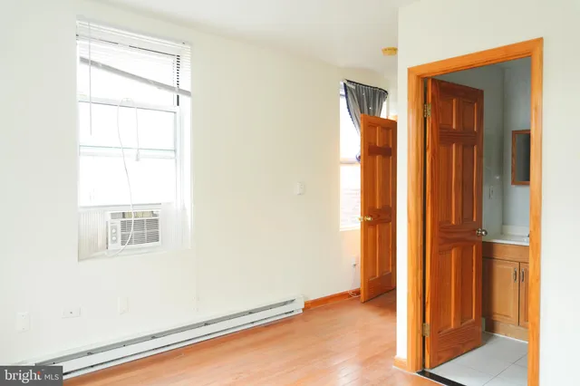 a view of an empty room with closet and a window