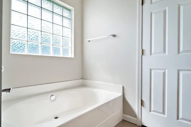 a bathroom with bathtub and window
