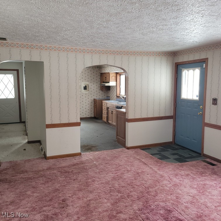 38227 Chestnut Ridge Road Elyria, OH 44035 - Photo 10 of 36 Foyer entrance with wallpapered walls, arched walkways, dark carpet, and a textured ceiling