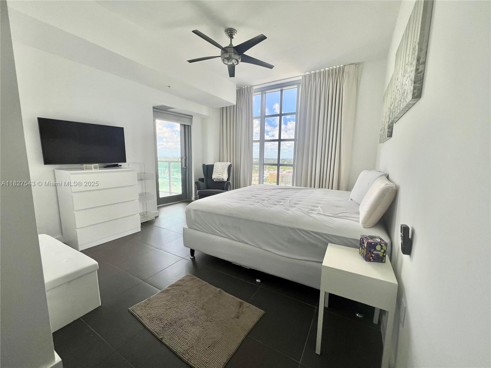 3301 Northeast 1st Avenue, Unit H2009 Miami, FL 33137 - Photo 19 of 45 a bedroom with a bed window and a flat screen tv