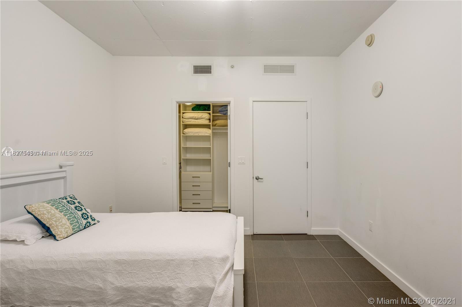 3301 Northeast 1st Avenue, Unit H2009 Miami, FL 33137 - Photo 25 of 45 a bedroom with a bed and a cabinets