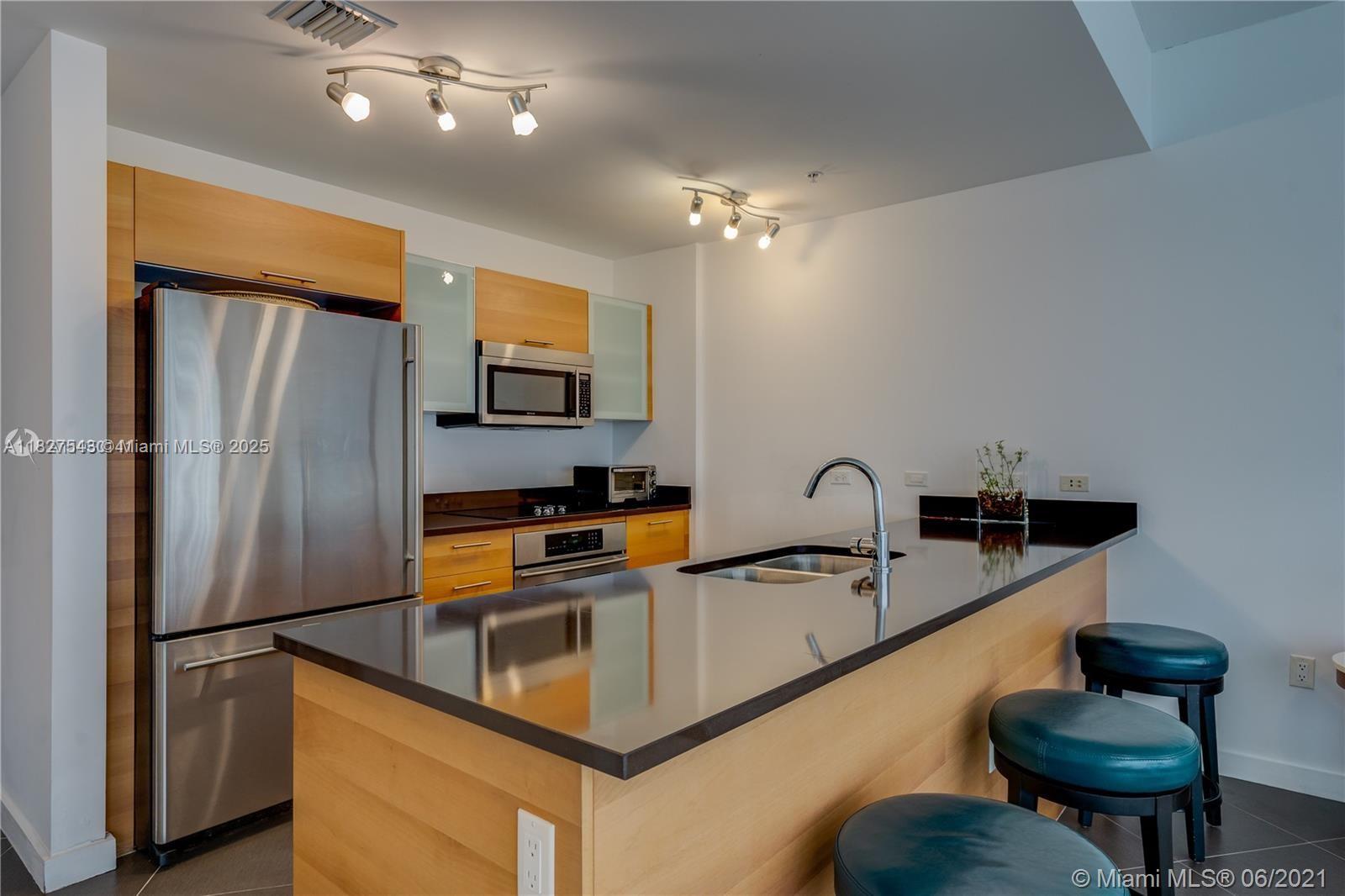 3301 Northeast 1st Avenue, Unit H2009 Miami, FL 33137 - Photo 3 of 45 a kitchen with stainless steel appliances granite countertop a sink refrigerator and cabinets