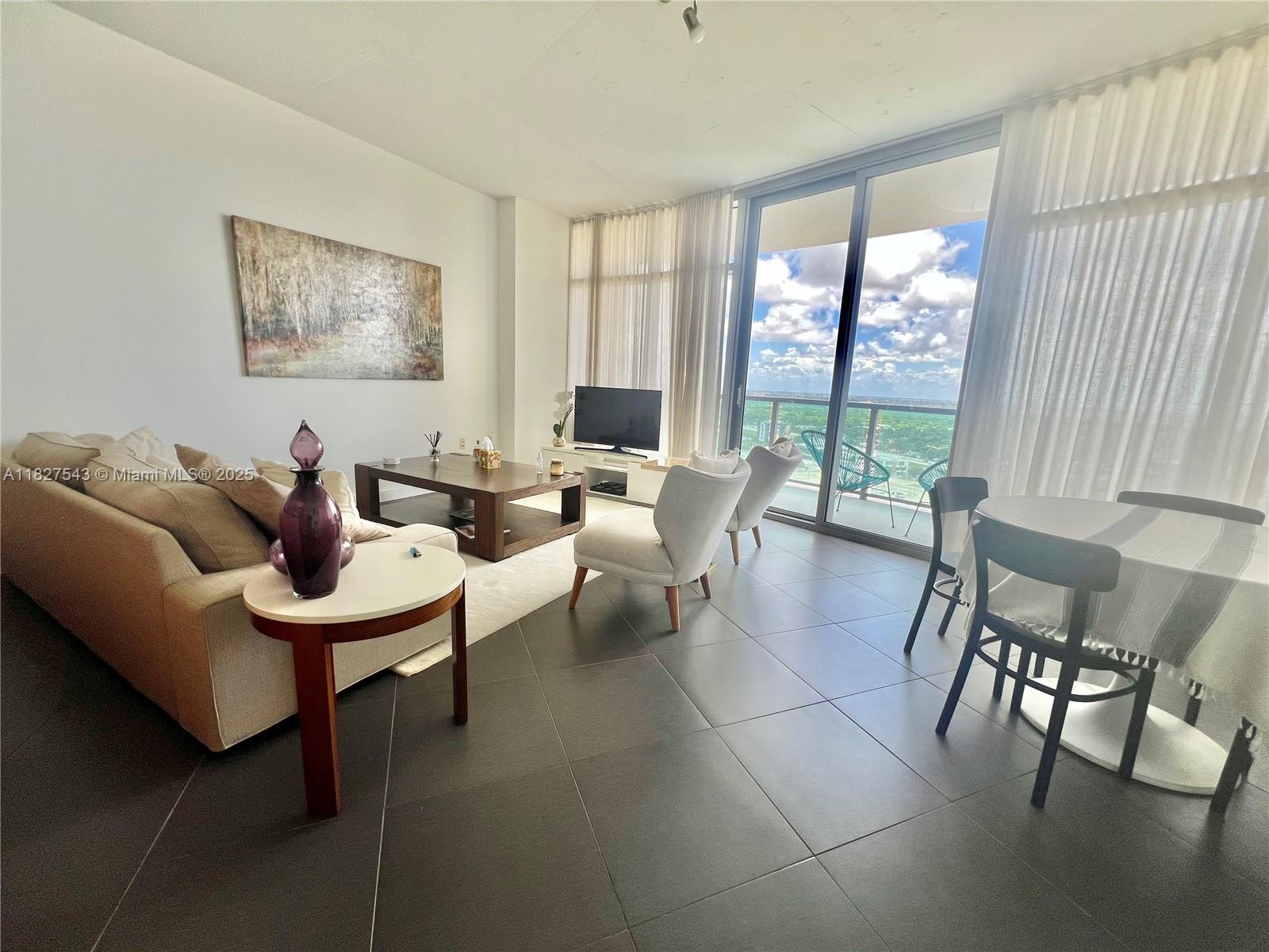3301 Northeast 1st Avenue, Unit H2009 Miami, FL 33137 - Photo 9 of 45 a living room with furniture and a floor to ceiling window