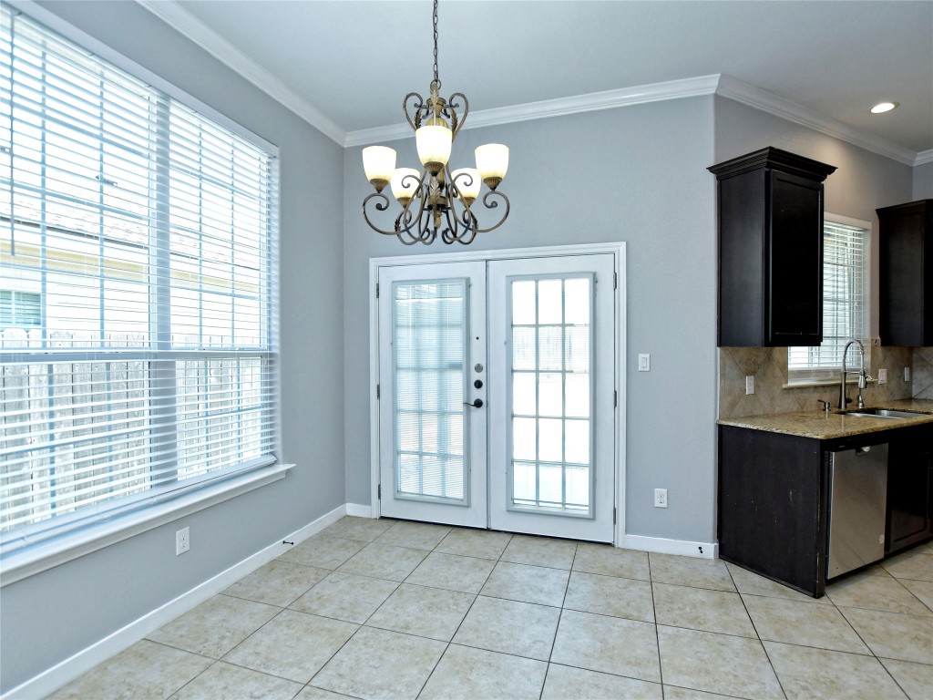 217 Geode Lane Jarrell, TX 76537 - Photo 12 of 35 Dining space featuring crown molding, light tile floors, recessed lighting, and a chandelier