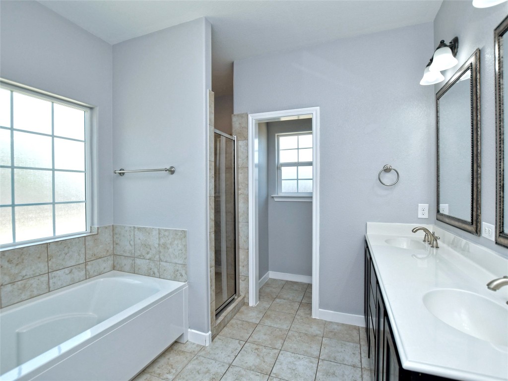 217 Geode Lane Jarrell, TX 76537 - Photo 23 of 35 Bathroom with a oversized bathtub, light tile floors, a stall shower, and double vanity