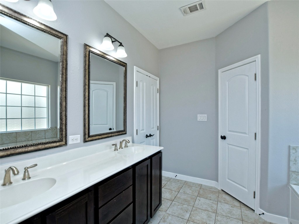 217 Geode Lane Jarrell, TX 76537 - Photo 25 of 35 Bathroom with double vanity and light tile patterned flooring