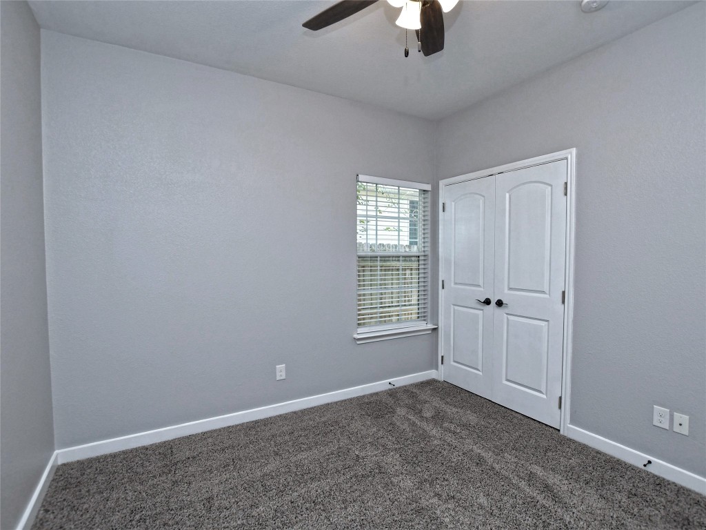 217 Geode Lane Jarrell, TX 76537 - Photo 27 of 35 Bedroom 2 carpeted featuring a closet and ceiling fan