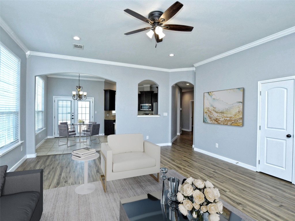 217 Geode Lane Jarrell, TX 76537 - Photo 6 of 35 Living area featuring ornamental molding, arched walkways, recessed lighting, a chandelier, and wood finished floors
