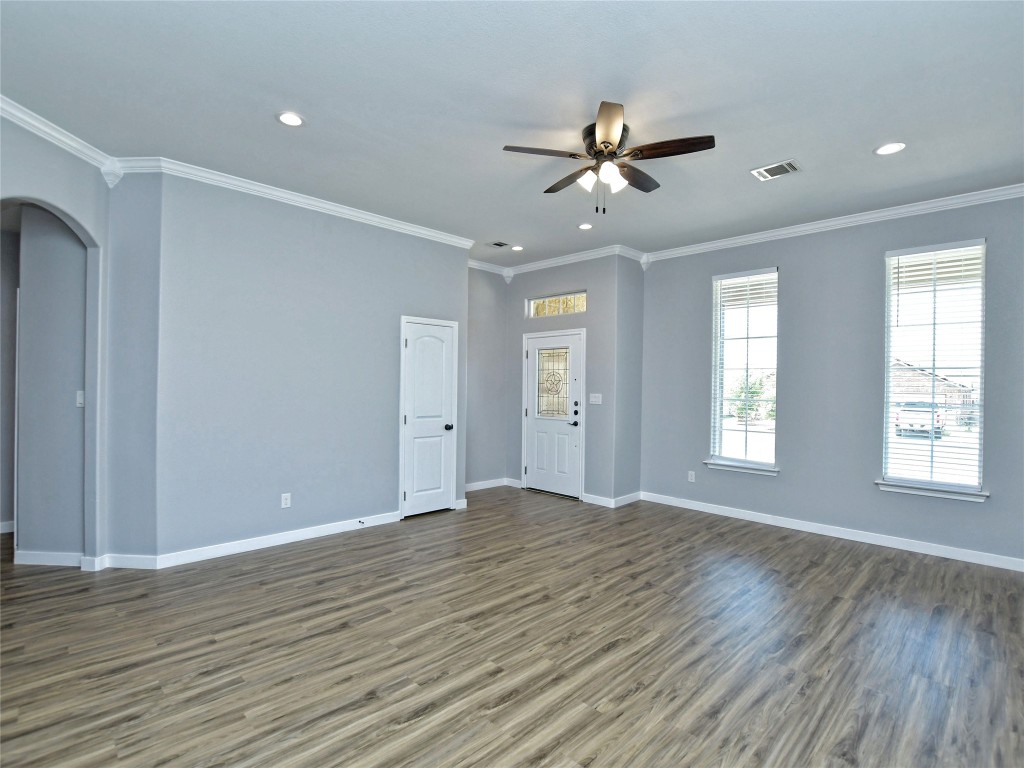 217 Geode Lane Jarrell, TX 76537 - Photo 9 of 35 Unfurnished living room with ornamental molding, wood finished floors, arched walkways, recessed lighting, and a ceiling fan