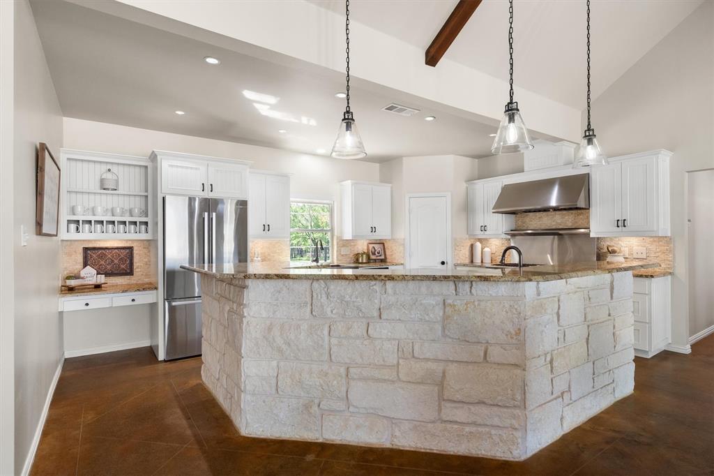 2431 Dr Sanders Road Cross Roads, TX 76227 - Photo 13 of 40 a large kitchen with stainless steel appliances kitchen island granite countertop a table and chairs in it