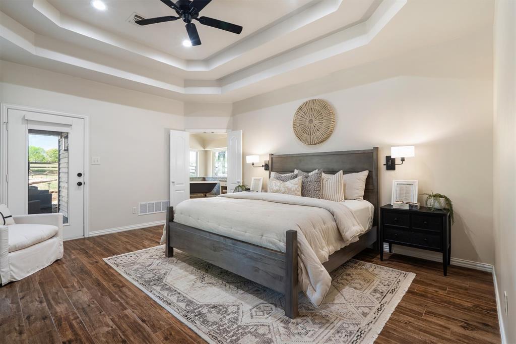 2431 Dr Sanders Road Cross Roads, TX 76227 - Photo 17 of 40 a bedroom with a bed and dresser with wooden floor
