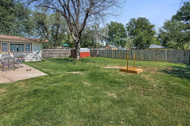 a backyard of a house with childrens swings and slides