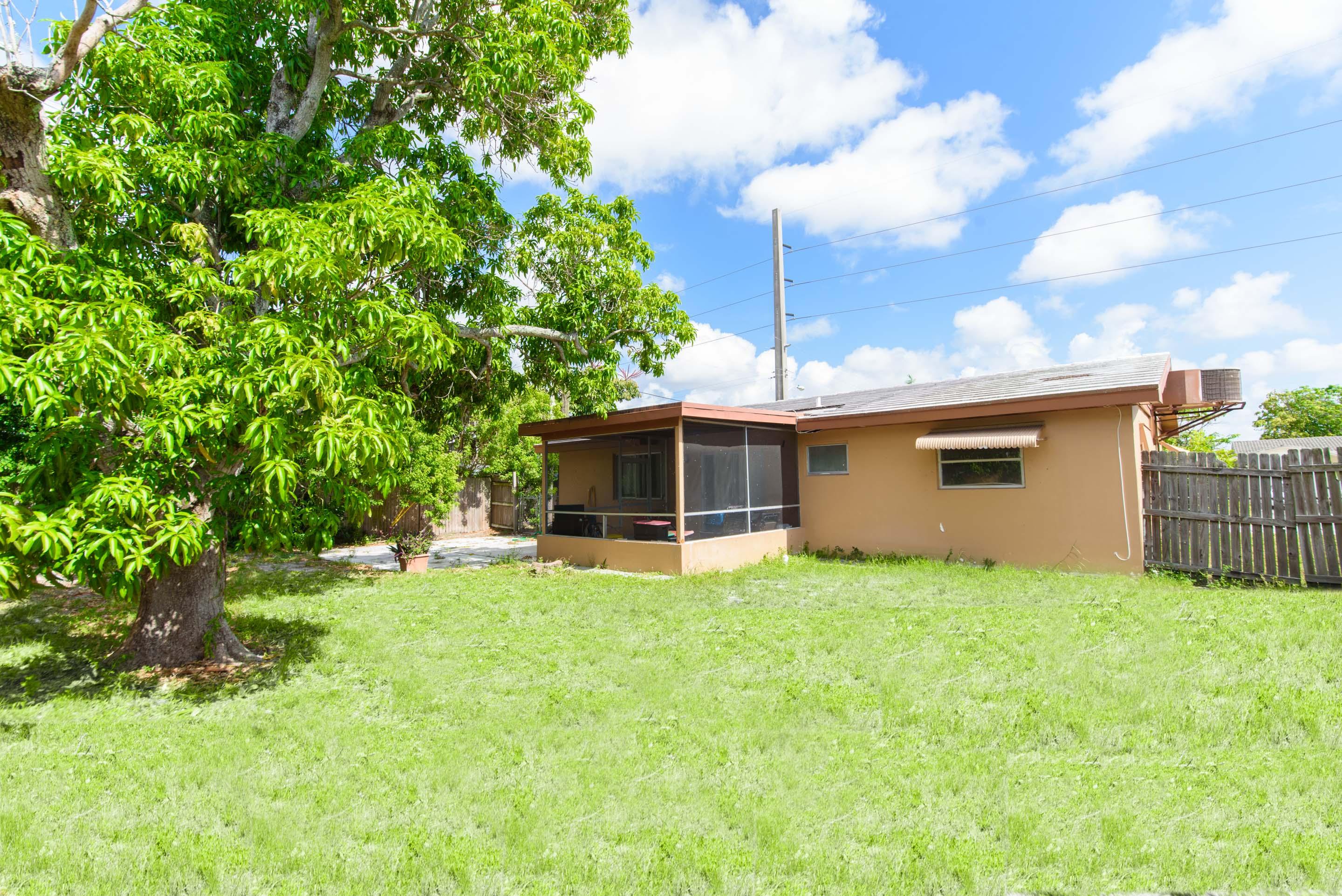 700 Southwest 14th Street Deerfield Beach, FL 33441 - Photo 2 of 13 a view of a backyard with plants and a tree