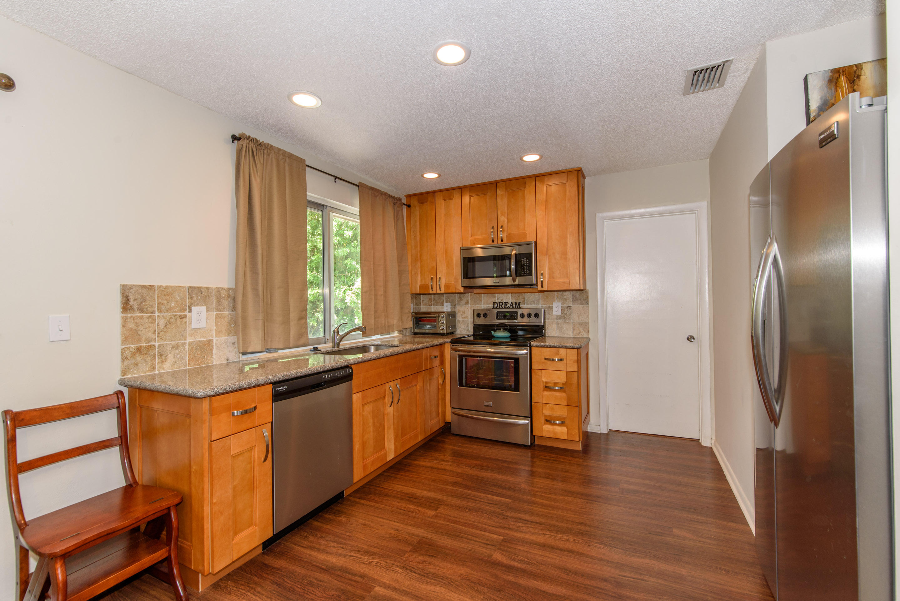 700 Southwest 14th Street Deerfield Beach, FL 33441 - Photo 5 of 13 a kitchen with stainless steel appliances granite countertop a stove a sink and a refrigerator
