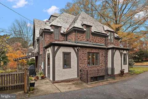 a front view of a house with a tree