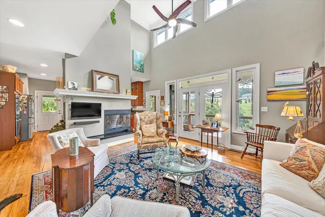a living room with furniture kitchen view and large windows