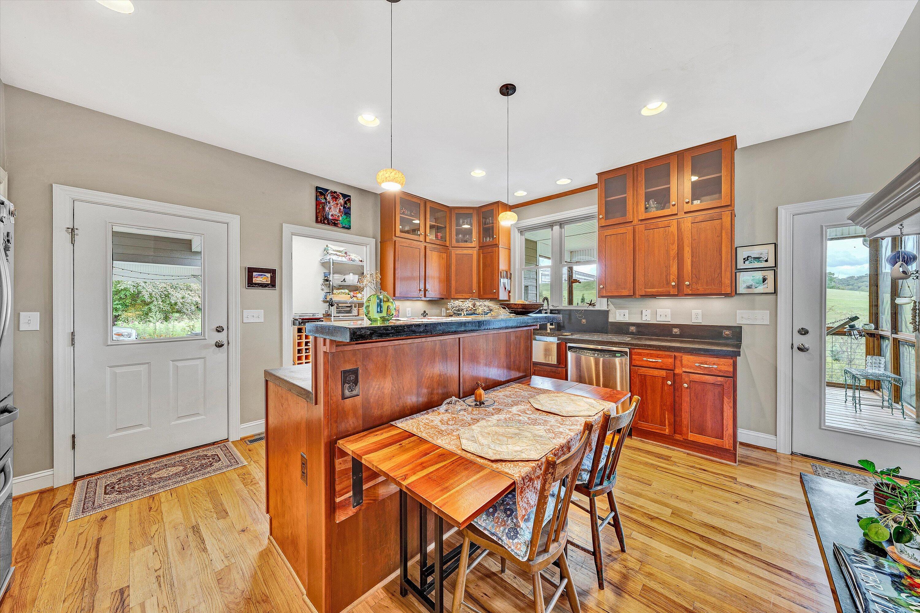 84 Green Level Road Boones Mill, VA 24065 - Photo 21 of 57 a kitchen with stainless steel appliances granite countertop a stove top oven a sink a dining table and chairs