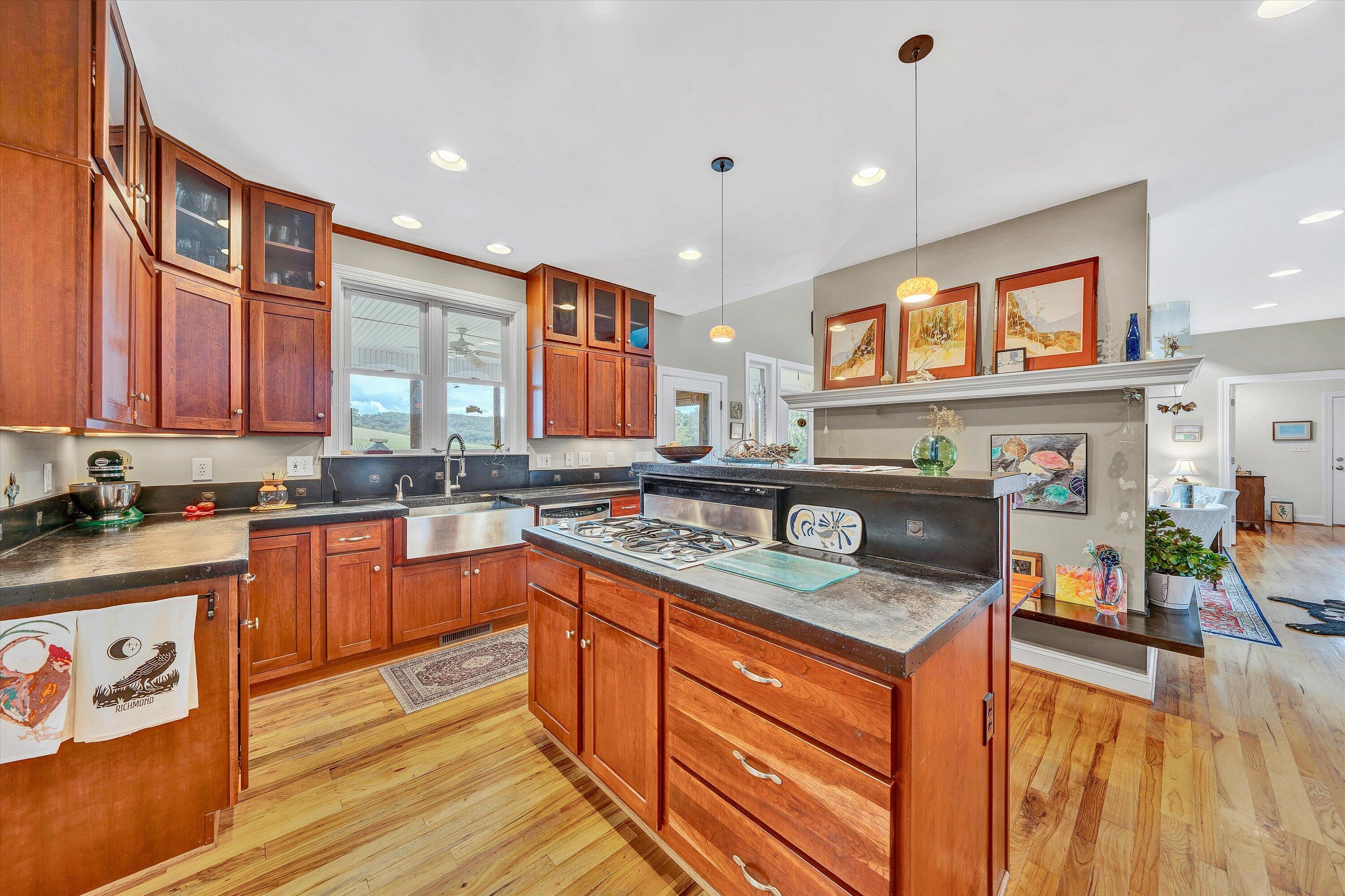 84 Green Level Road Boones Mill, VA 24065 - Photo 22 of 57 a kitchen with stainless steel appliances granite countertop a sink stove and wooden cabinets
