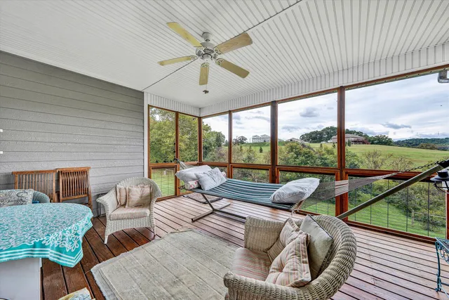 a living room with furniture and floor to ceiling windows