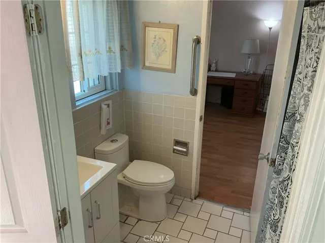 a bathroom with a sink a toilet a window and vanity