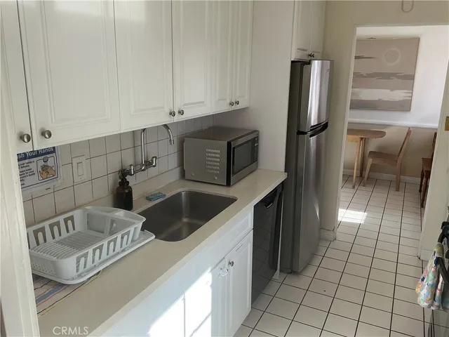 a kitchen with granite countertop a refrigerator a stove and a sink