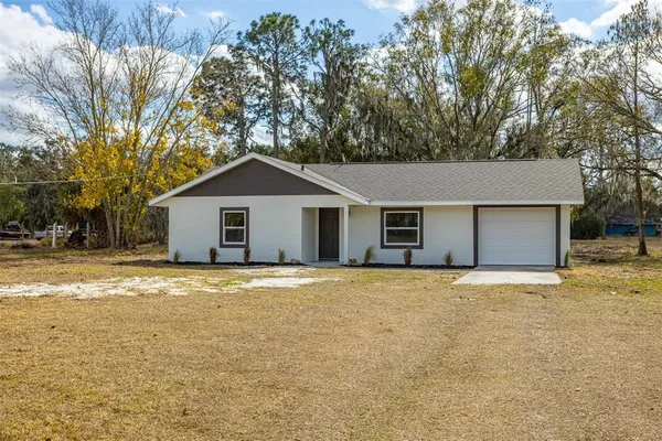 a front view of house with yard and trees