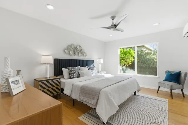 a bedroom with a bed and a painting on the wall