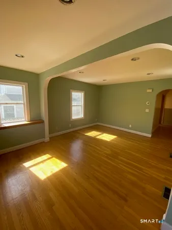 a view of a big room with wooden floor and windows