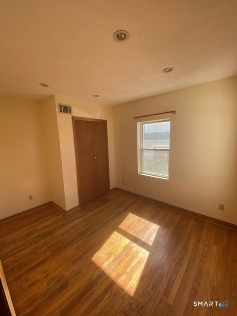 42-44 High Street Naugatuck, CT 06770 - Photo 6 of 8 an empty room with wooden floor cabinet and windows
