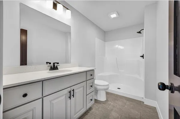 a bathroom with a toilet a sink a mirror a bathtub and vanity