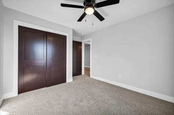 a view of empty room with window and ceiling fan
