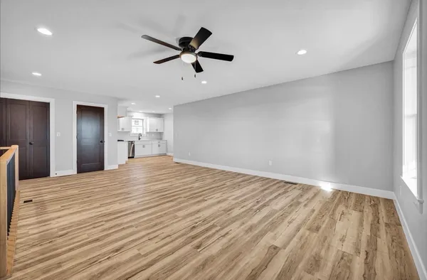 a view of empty room with wooden floor and window