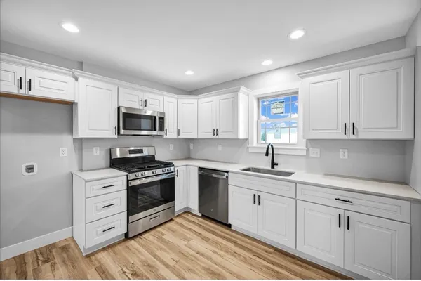 a kitchen with white cabinets stainless steel appliances and sink