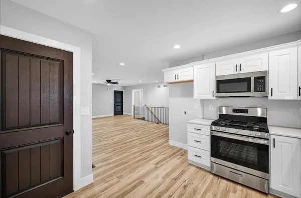 a kitchen with granite countertop a stove top oven and cabinets