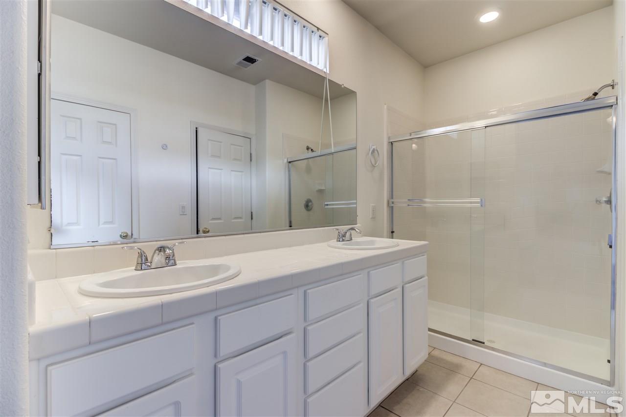 9724 Ripple Way Reno, NV 89521 - Photo 14 of 19 a bathroom with a sink double vanity granite tub shower and a mirror