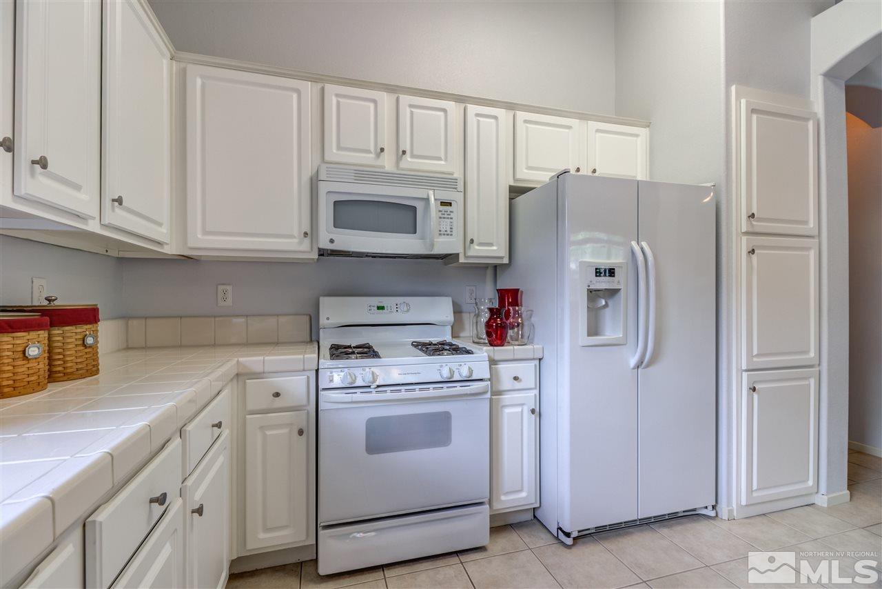 9724 Ripple Way Reno, NV 89521 - Photo 8 of 19 a kitchen with white cabinets and white appliances